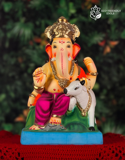 Cross Leg Vasru Ganesh idol in purple and orange with cow companion, 14 inches, eco-friendly Shadu Mathi clay murti